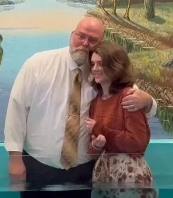 Pastor John Loudin hugs his daughter, Serenity, before baptizing her last Sunday.